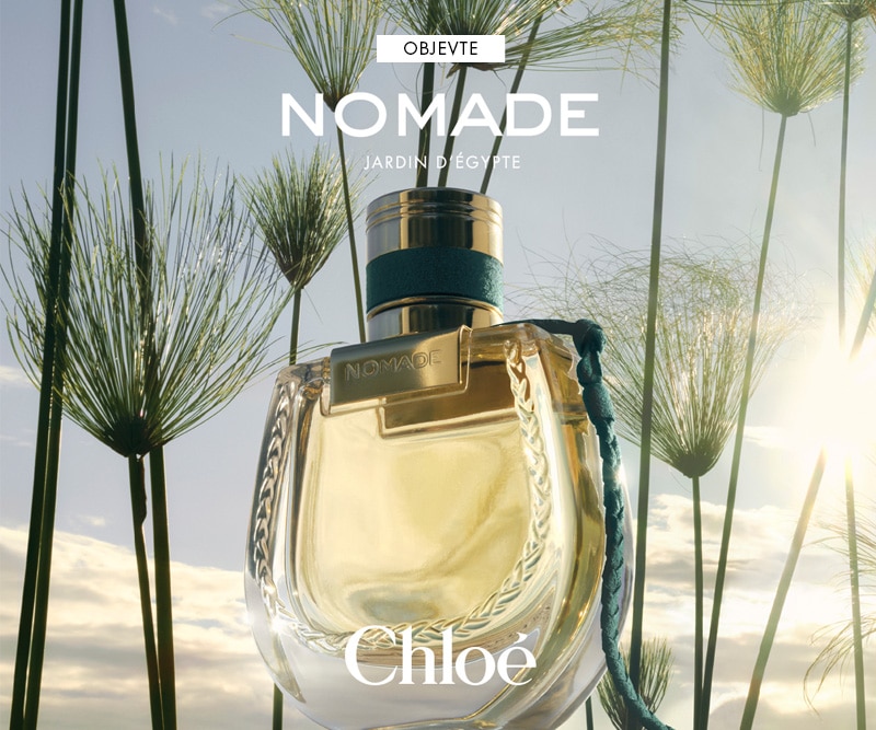 Dámský parfém Chloé Nomade Jardin d’Égypte v elegantním zlatém flakonu na pozadí slunečného přírodního motivu